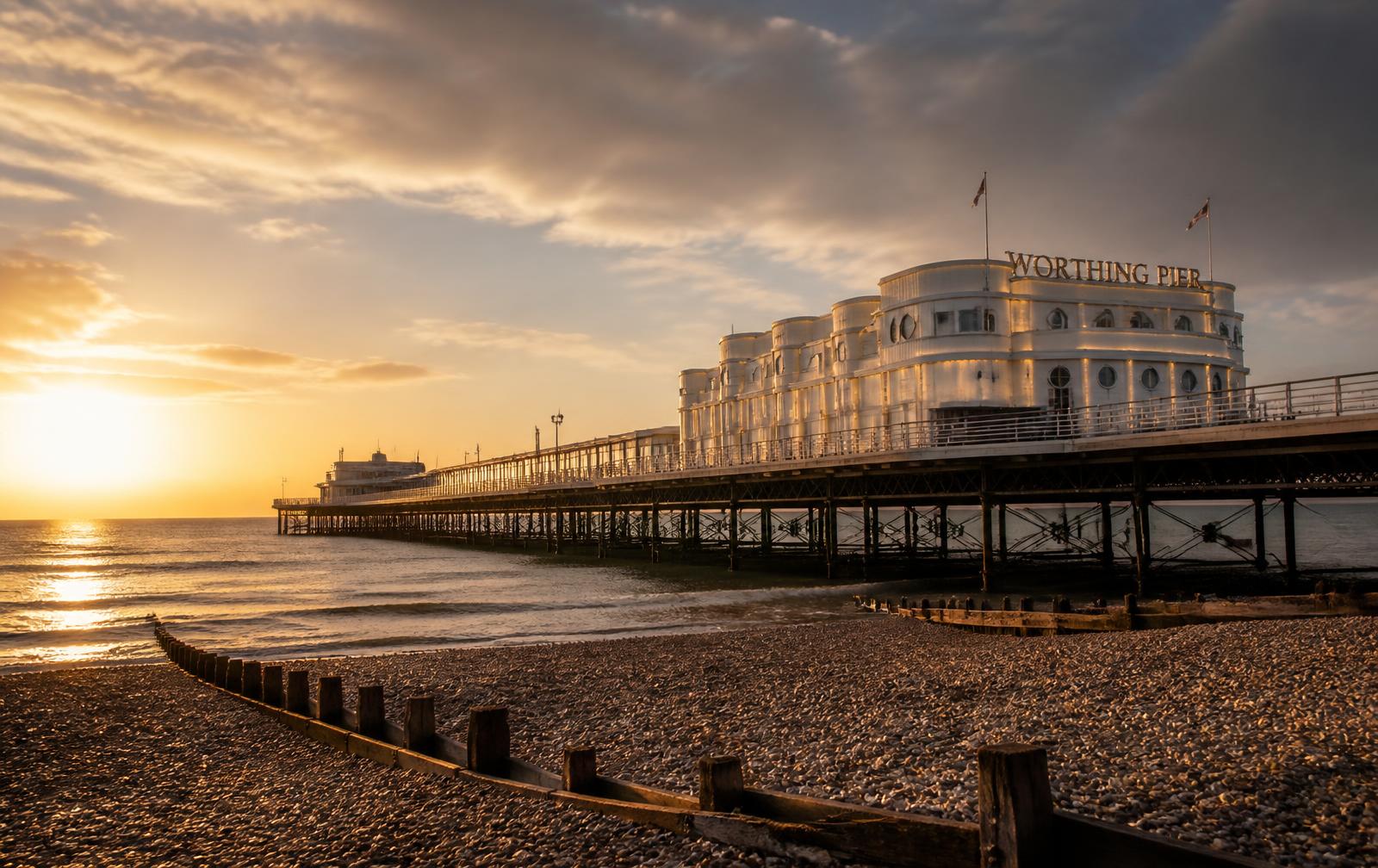 Worthing Pier at golden hour, with the Art Deco pavilion and pebble beach on the West Sussex coast